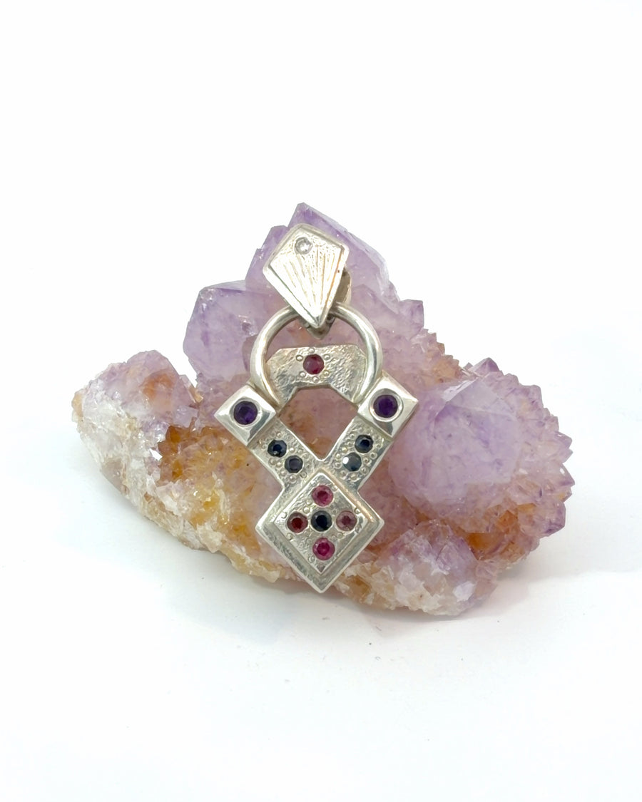Handcrafted geometric sterling silver pendant featuring textured architectural details and round-cut amethyst gemstones.