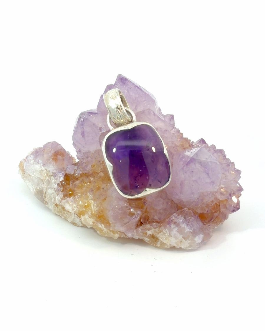 Handcrafted freeform natural amethyst pendant in sterling silver bezel setting with a polished deep purple gemstone.