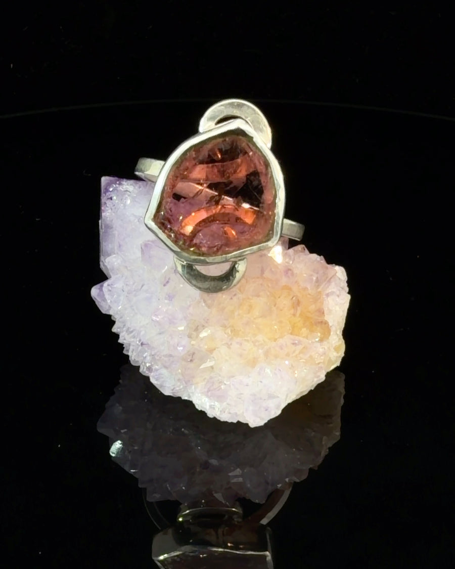 Handcrafted sterling silver ring featuring a freeform faceted natural Pink Tourmaline in a polished bezel setting with decorative loop shoulders, Size 8.