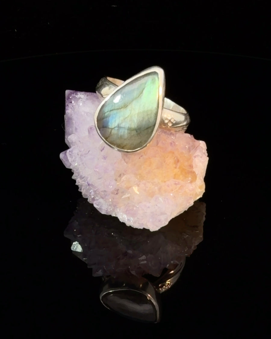 Natural teardrop Labradorite cabochon bezel set in a sterling silver textured band ring, size 7.5, displaying vibrant blue and green labradorescence.