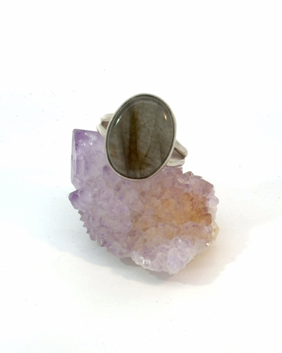 Natural pink Labradorite oval cabochon bezel-set in a sterling silver split shank solitaire ring, size 6, featuring beautiful natural inclusions.