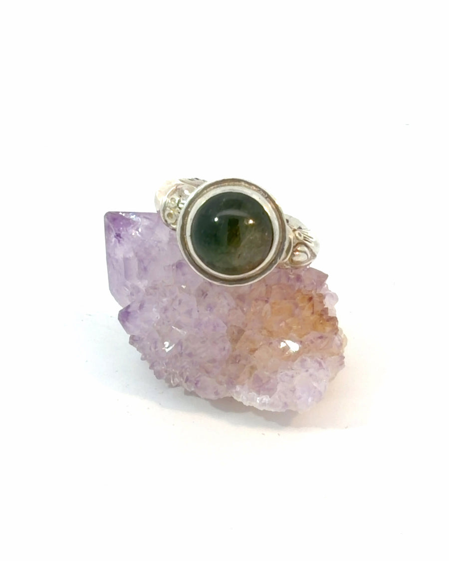 Handcrafted sterling silver ring featuring a deep green Tourmaline cabochon in a smooth bezel setting with a textured claw and bone inspired band, size 7.5.