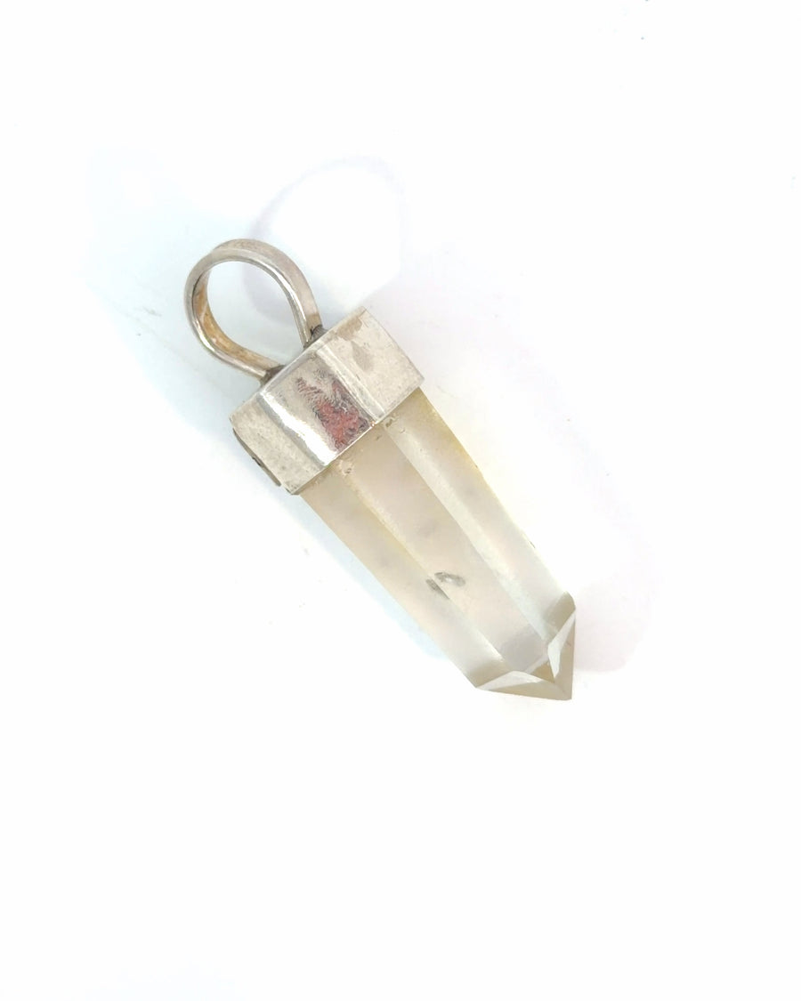 Natural clear hexagonal crystal point pendant with silver cap and bail in a minimalist design.
