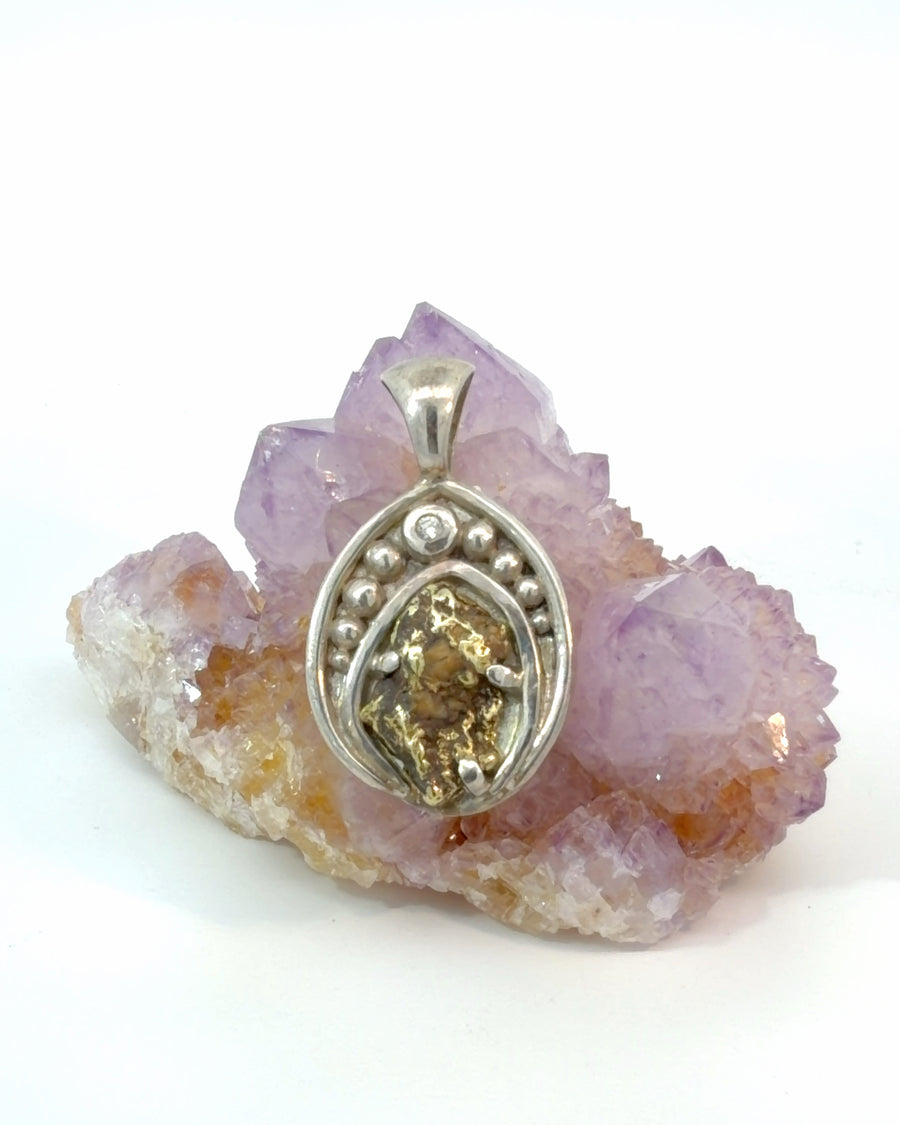 Handcrafted sterling silver pendant featuring a natural gold nugget with quartz with a faceted diamond accent and decorative silver beadwork.
