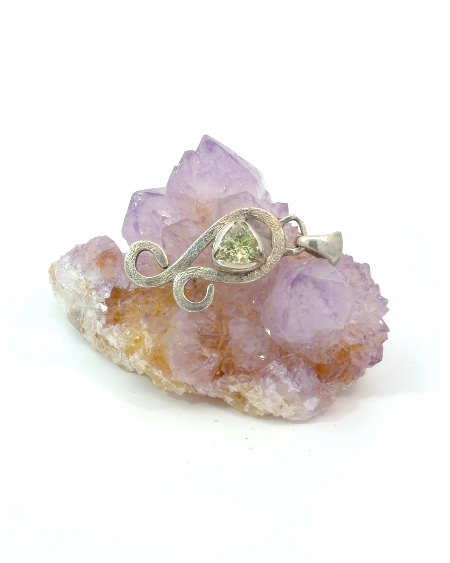 Handcrafted sterling silver pendant featuring a natural Chrysoberyl gemstone in a flowing organic design with a textured finish. A unique artisan gemstone pendant.
