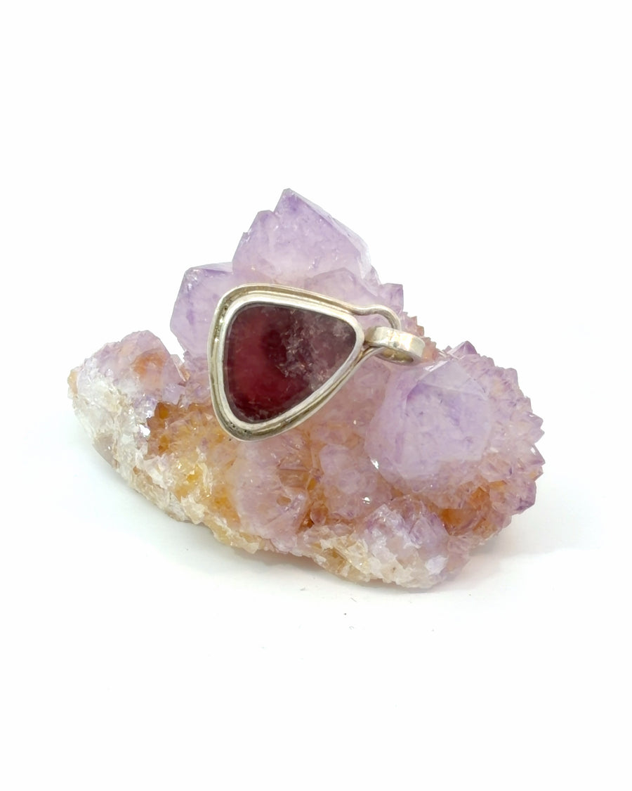 Natural deep red tourmaline pendant featuring a freeform gemstone in a handcrafted sterling silver bezel setting. A unique artisan jewelry piece for everyday wear or gifting.
