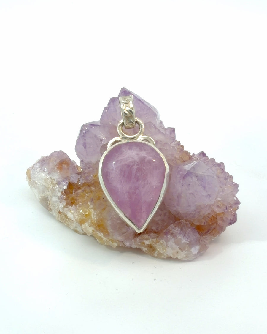 Natural pear-shaped pink Kunzite pendant in a handcrafted sterling silver bezel setting with an articulated decorative bail.

