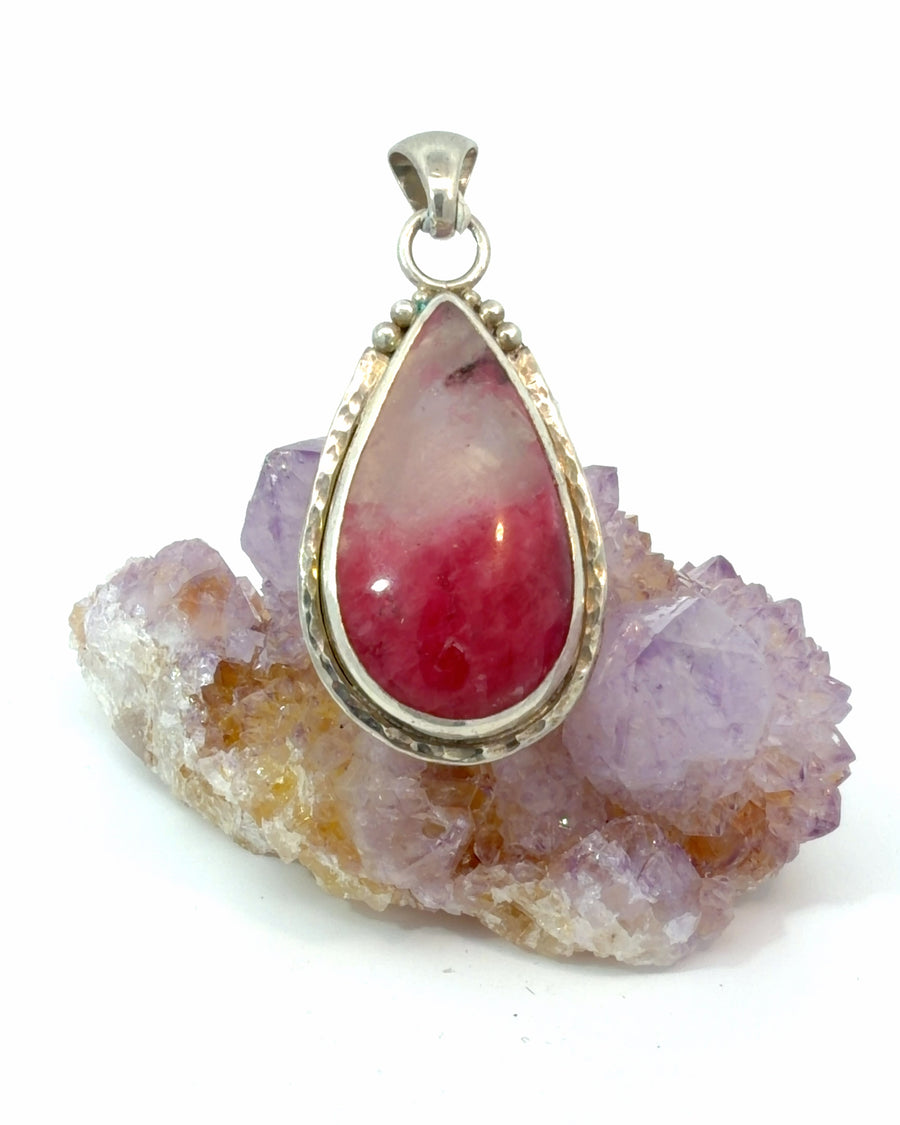 Handcrafted sterling silver pendant featuring a pear-shaped natural Rhodonite and Quartz cabochon with a white-to-vibrant pink color gradient, hammered bezel, and decorative silver bead accents.