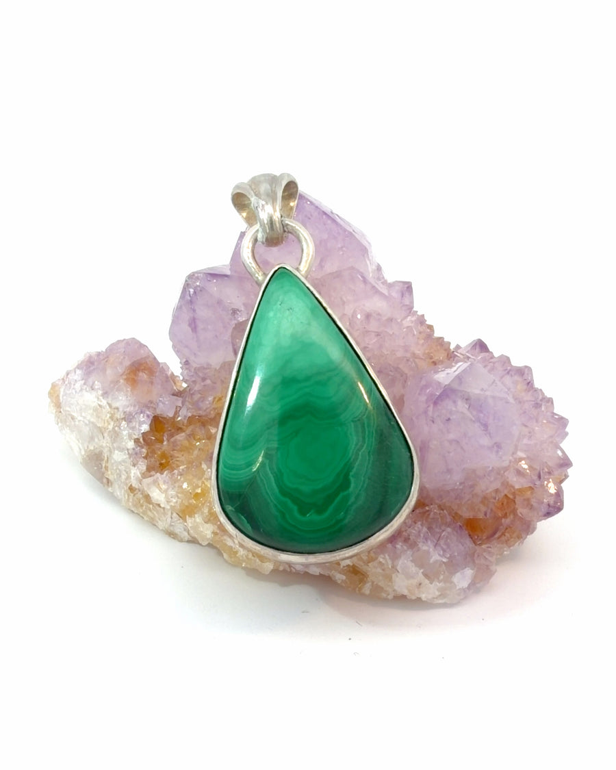 Large natural teardrop malachite cabochon pendant in a handcrafted sterling silver bezel setting with vibrant green banding.