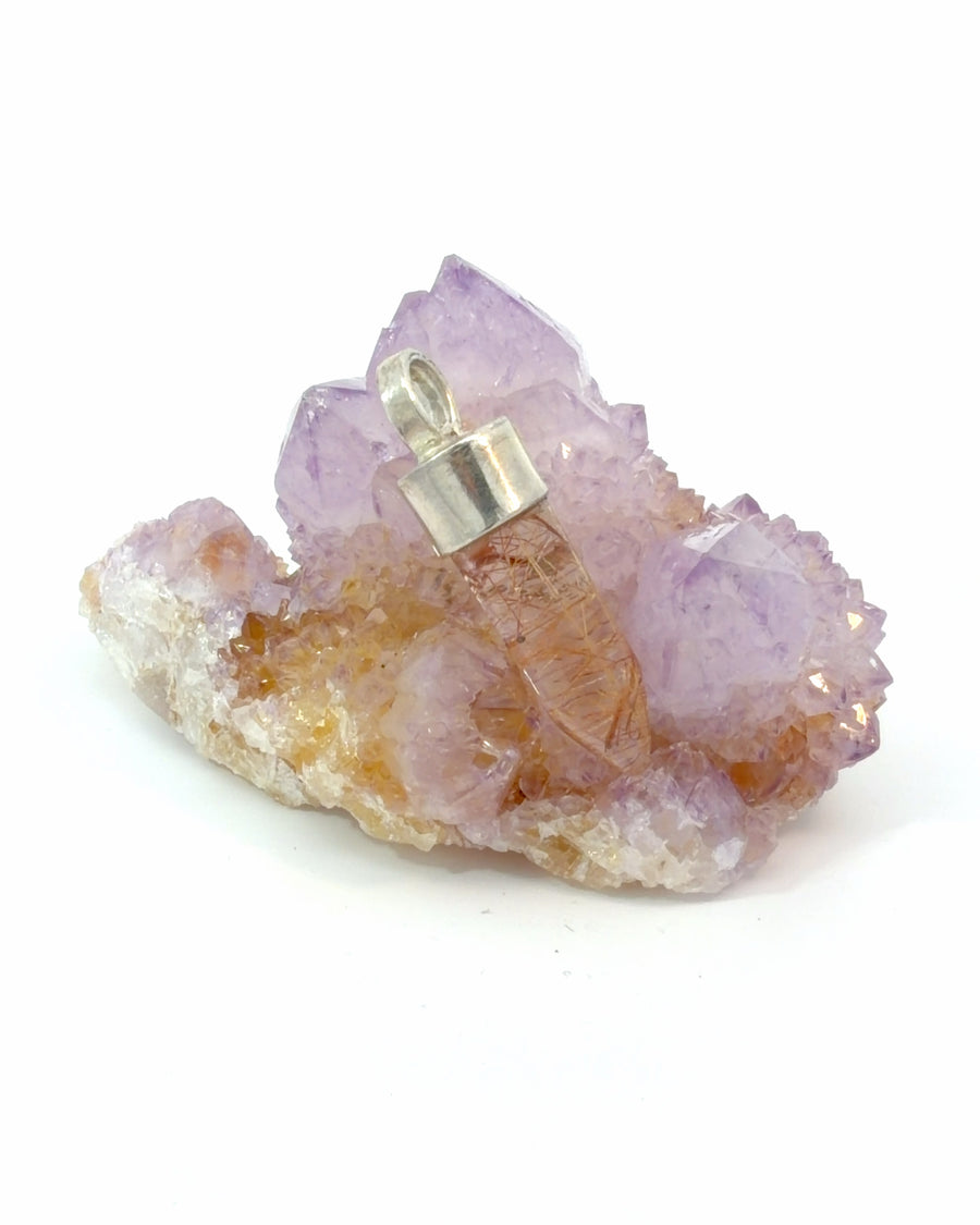 Natural faceted rutilated quartz point pendant with golden rutile inclusions and sterling silver cap.