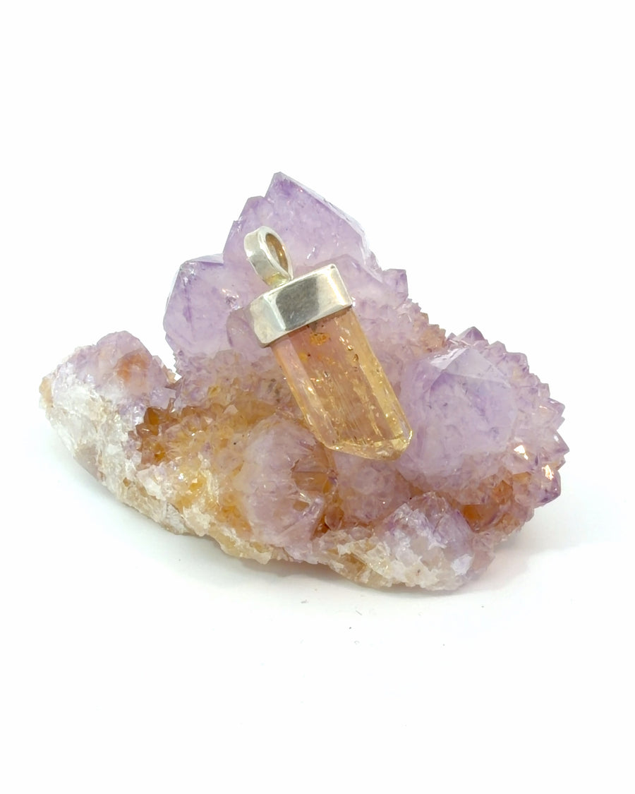 Handcrafted sterling silver pendant featuring a genuine raw golden topaz crystal in a polished silver cap setting.