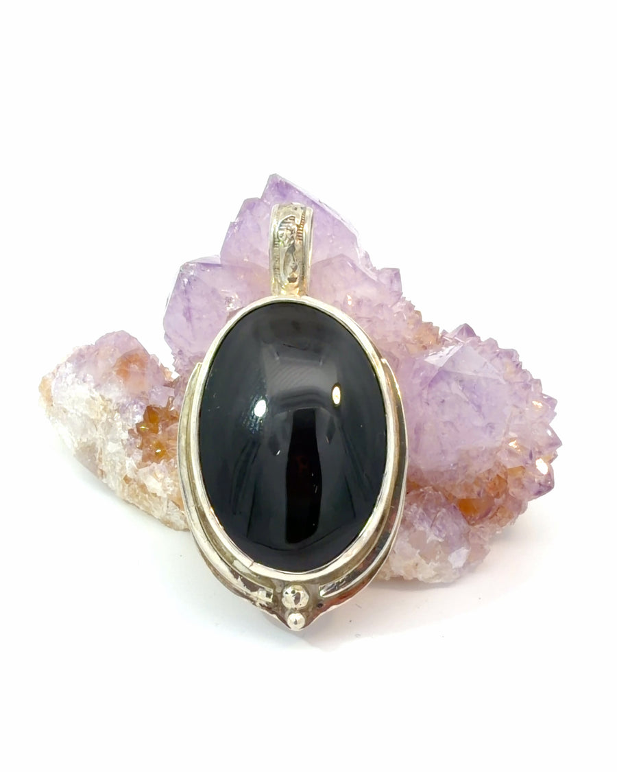 Handcrafted sterling silver Rainbow Obsidian pendant displaying vibrant iridescent flashes with decorative bail and silver bead accents.