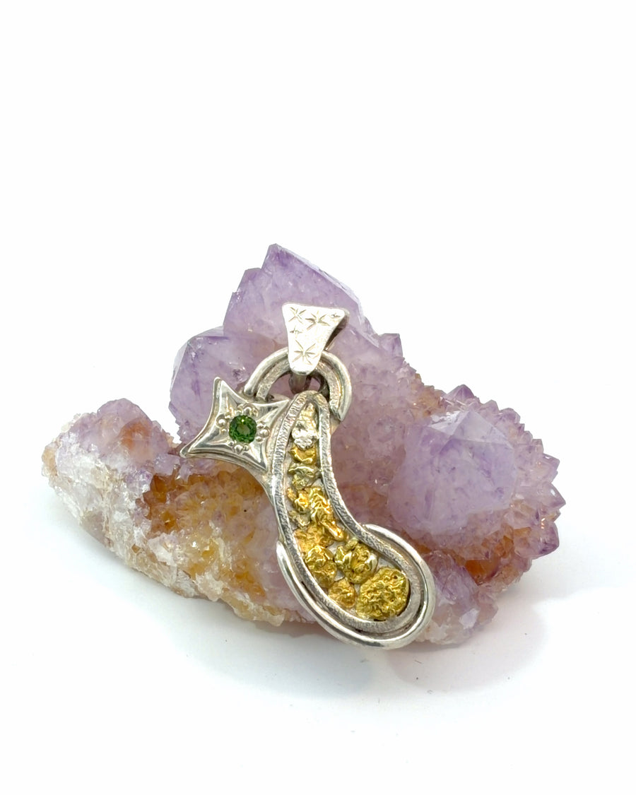 Handcrafted sterling silver pendant featuring textured gold nuggets and a natural green tourmaline set in a four-point star with an engraved decorative bail.