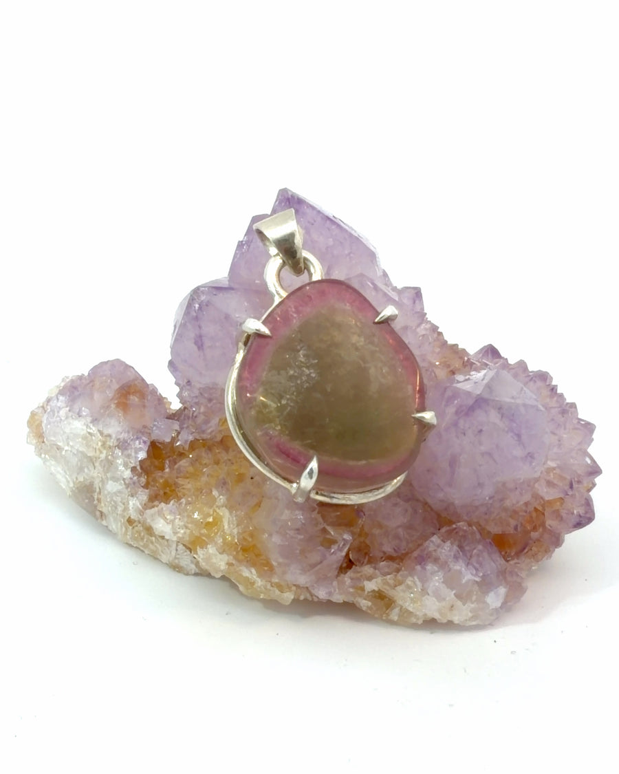 Natural watermelon tourmaline slice pendant featuring vibrant pink and green color zoning in a sterling silver prong setting.