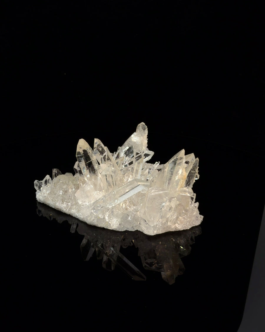Natural Arkansas clear quartz crystal cluster with transparent and translucent points on a raw mineral base, 6.8 cm