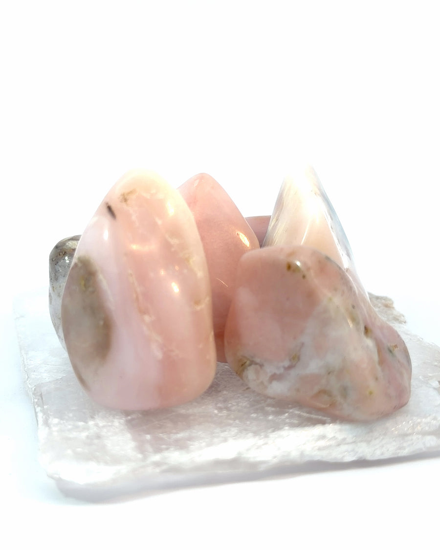 Set of 3 genuine tumbled Pink Opal crystals with polished soft pink surfaces for crystal collecting, meditation, and healing practices.