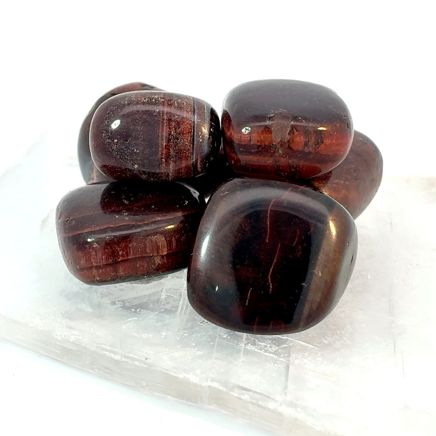 Set of 4 tumbled Red Tiger’s Eye stones with polished reddish-brown color and golden chatoyant bands