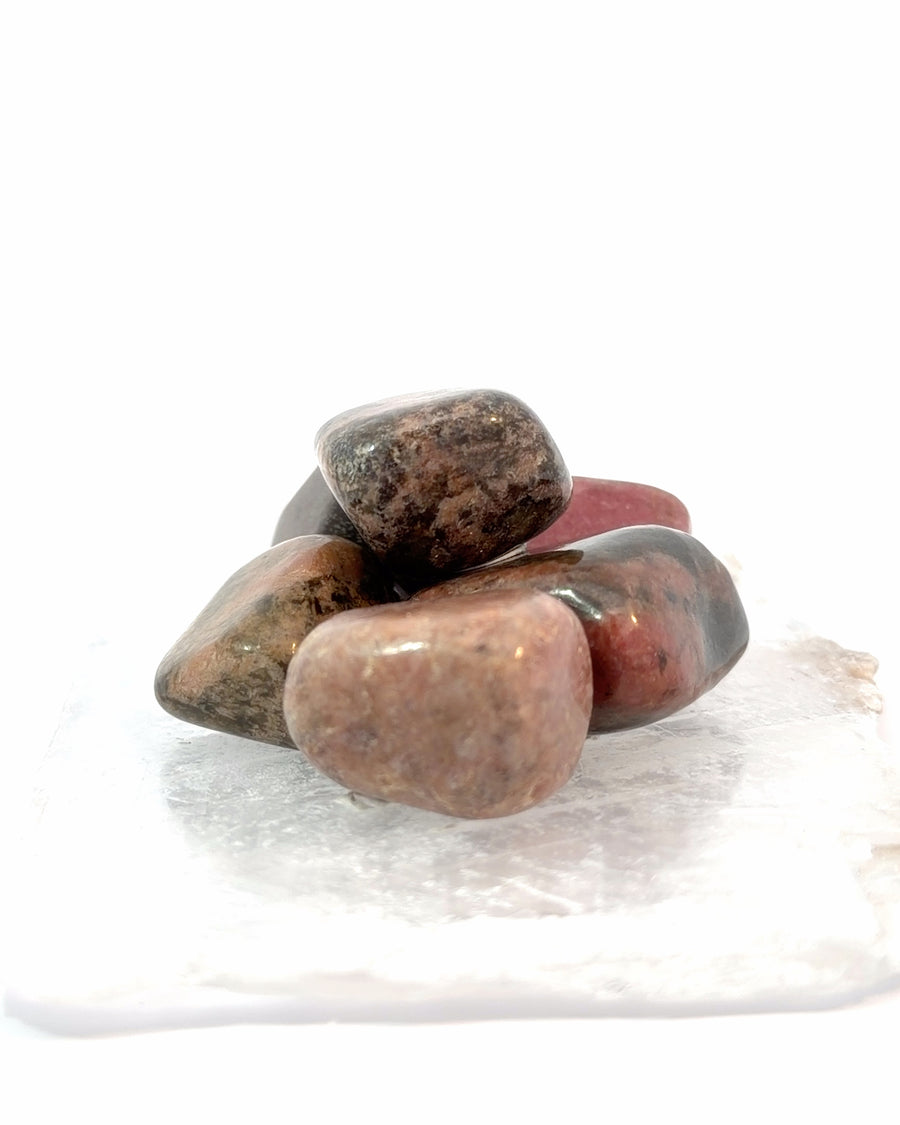 Set of 4 tumbled Rhodonite stones with natural pink color and black veining