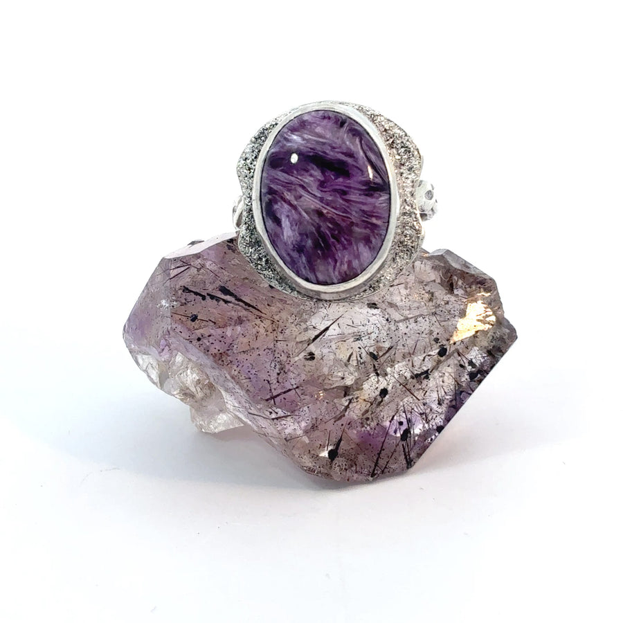 Handcrafted sterling silver ring featuring a genuine oval Russian Charoite cabochon in a bezel setting with reticulated texture and woven band, size 6.5.