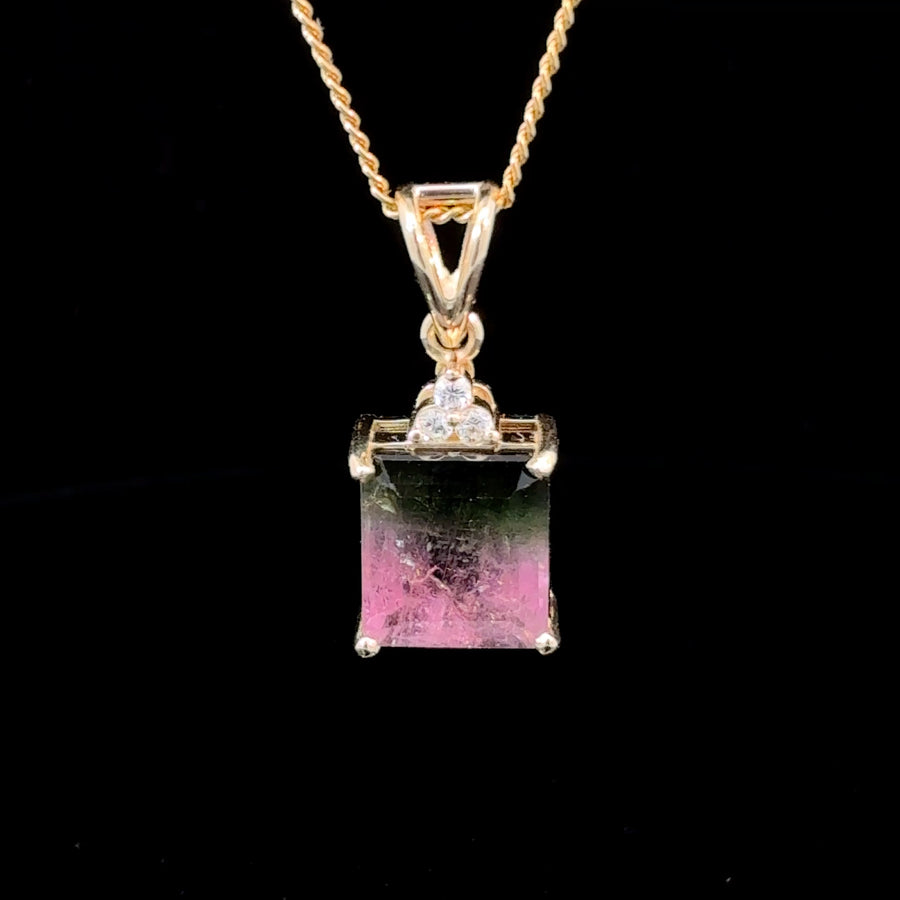 Handcrafted 14K gold pendant featuring a natural square-cut bi-color green and pink tourmaline with three brilliant diamonds in a triangular setting.