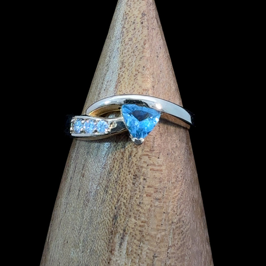 14K gold bypass ring featuring a trillion-cut blue topaz with three diamond accents, size 6.25.