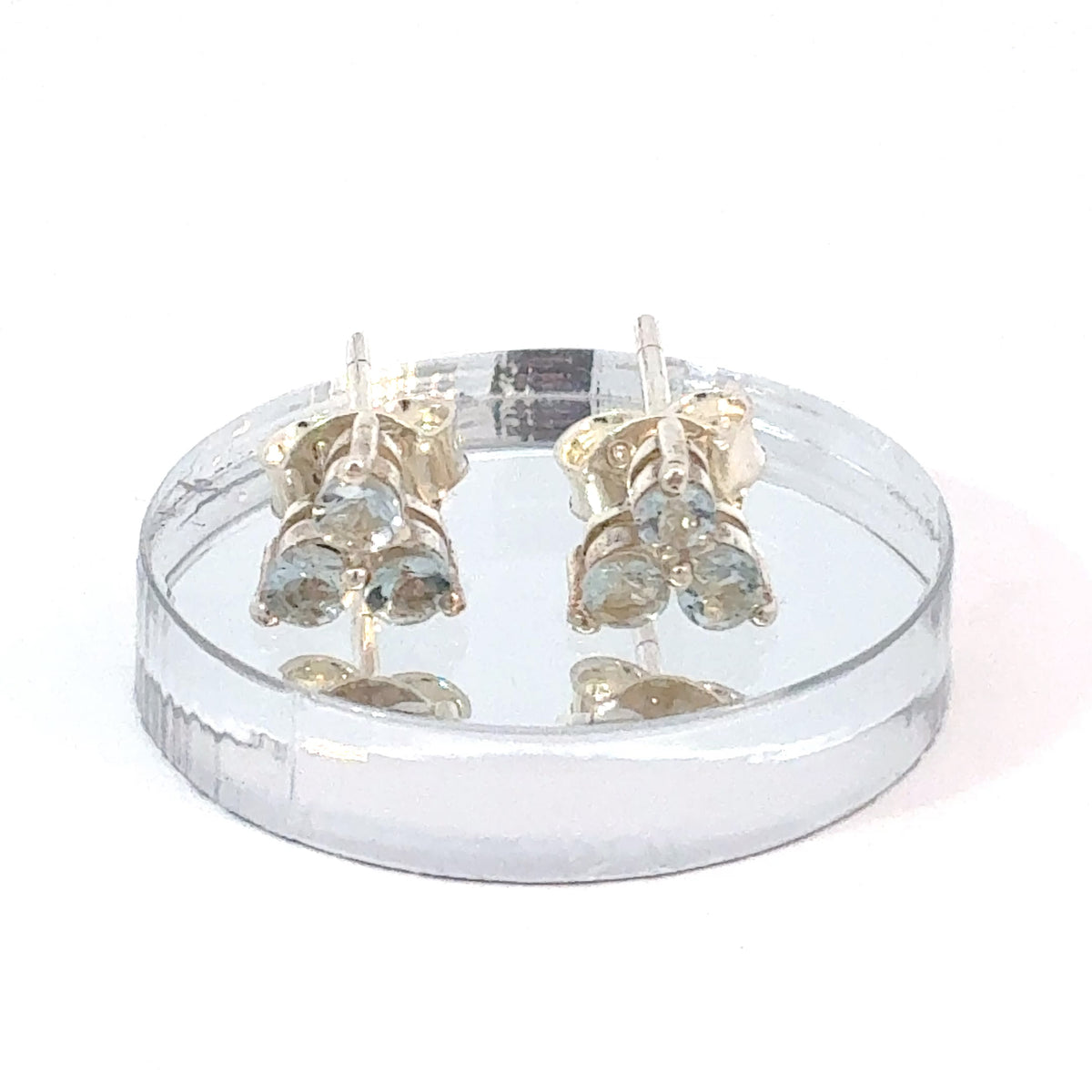 Aquamarine three-stone stud earrings with small round faceted pale blue gemstones